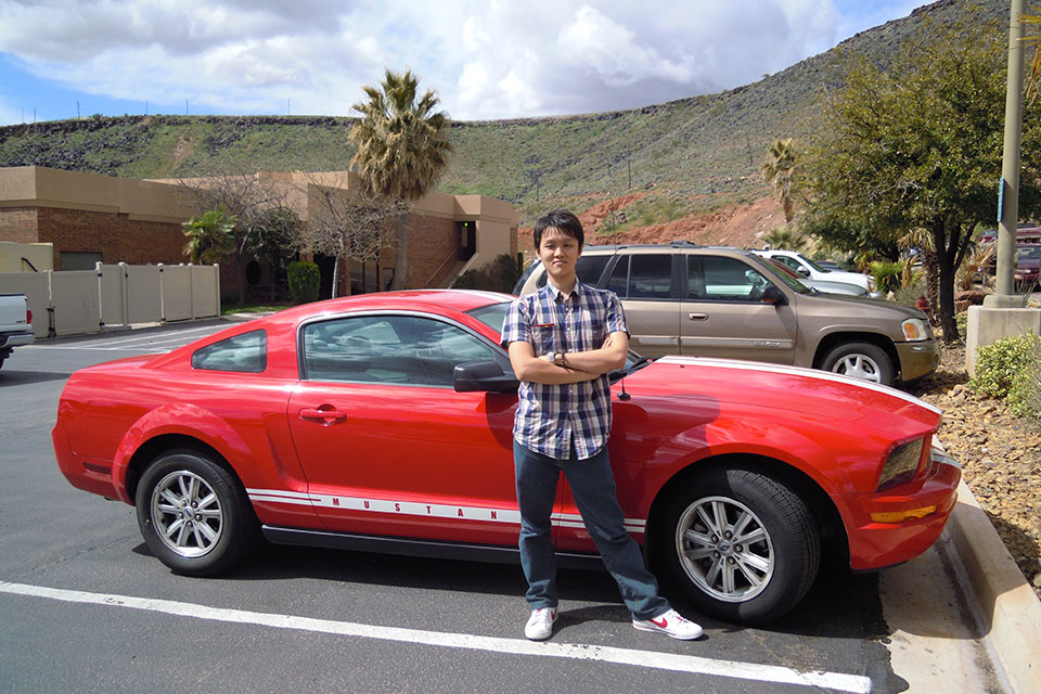 Jackson Yew standing beside a red Ford Mustang in Hurricane, Utah, 2011